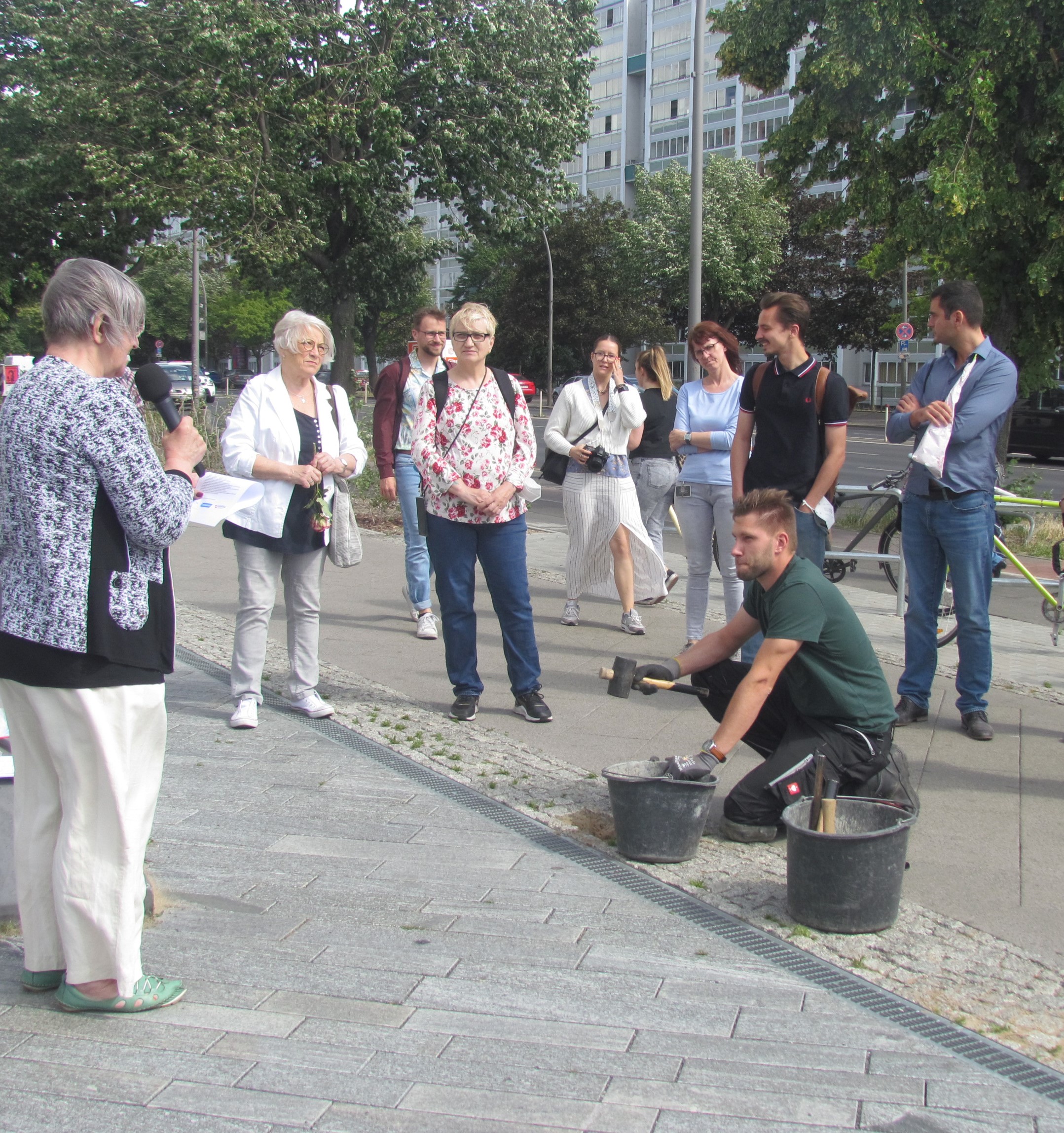 Menschen bei der Verlegung von Stolpersteinen.