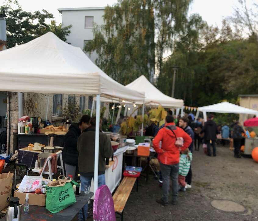 Marktstände und Besucher auf einem Gartenfest