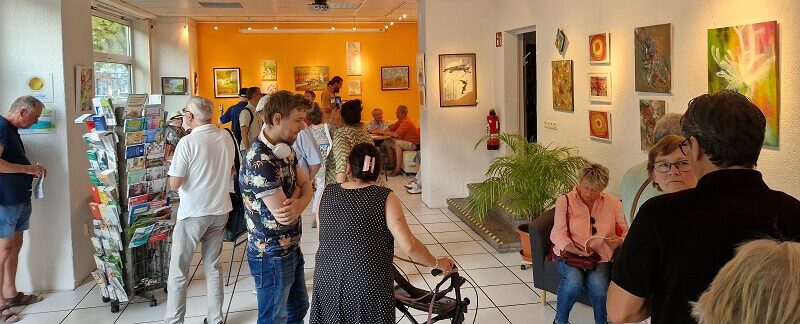 Der Raum der oskar galerie während der Vernissage: Besucher sind im Raum verteilt, unterhalten sich oder schauen sich Bilder an.