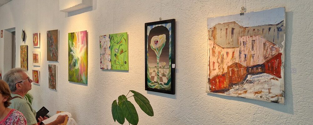 Eine Wand in der oskar galerie mit 11 Malereien.