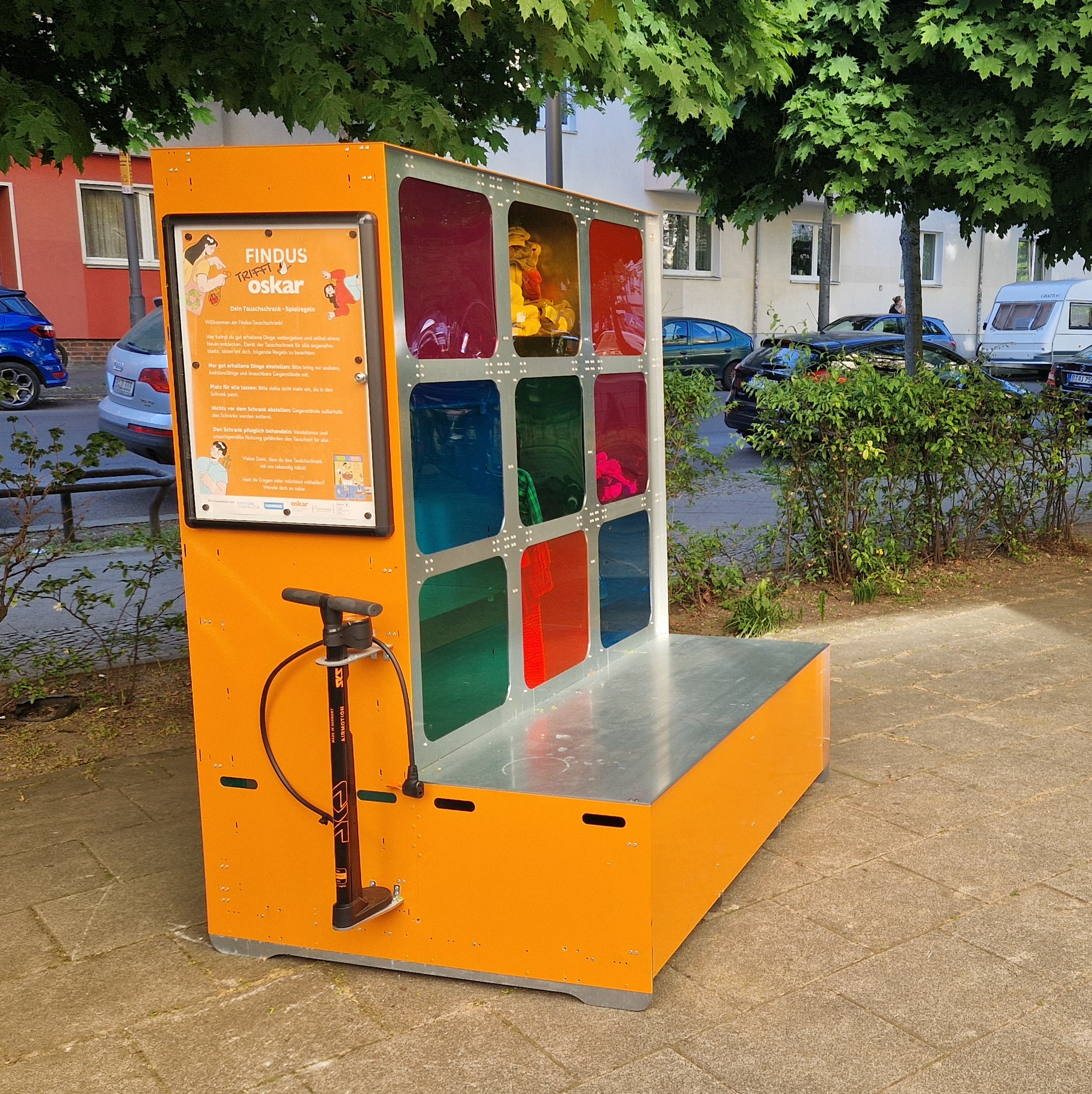 Der orangene Findus-Tauschschrank mit neun bunten Fenstern steht auf dem Platz vor der oskar Freiwilligenagentur.