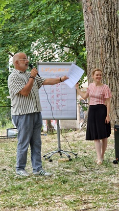 Der Moderator und die oskar Projektleiterin stehen neben einem Flipchart und schauen ins Publikum.